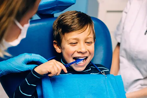 Pediatric Dentistry in Flagstaff | Child at the dentist - smiling child with toothbrush in mouth
