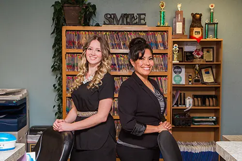 contact, Country Club Dental Flagstaff Cleaning Service - two people posing in front of a bookshelf