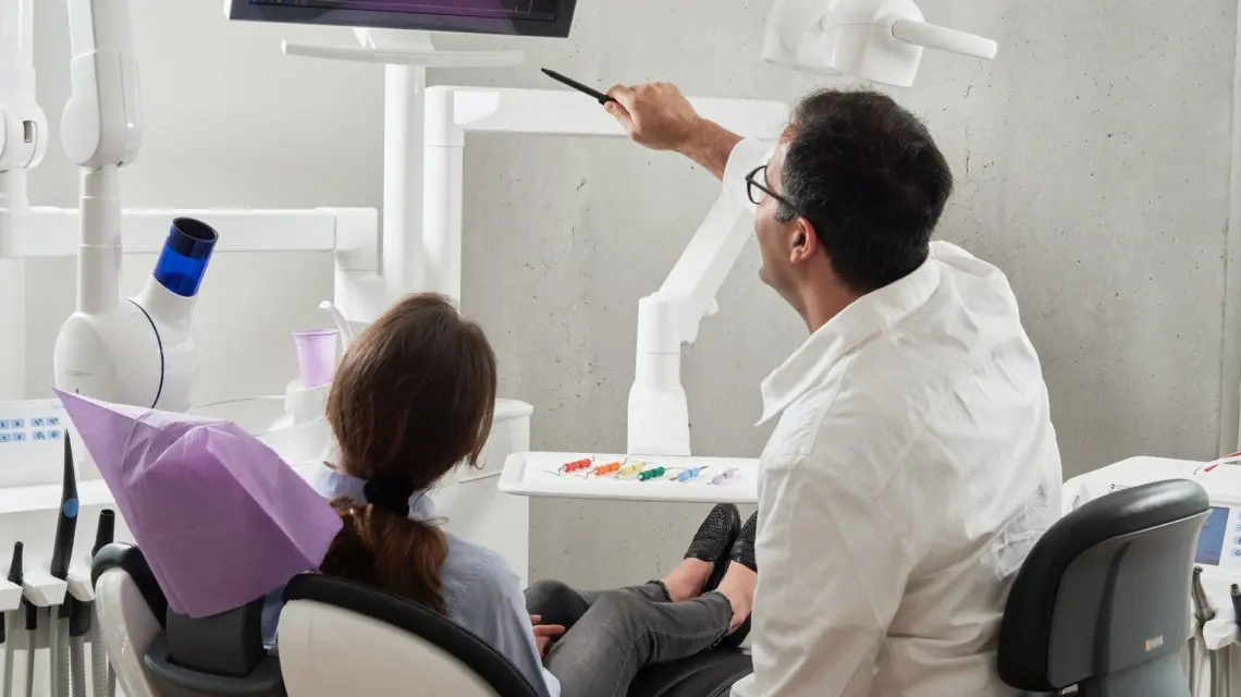 dental deep cleaning -- Dentist reviewing x-ray with patient