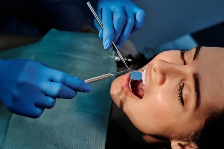 non-surgical root canal -- woman having teeth examined by dentist