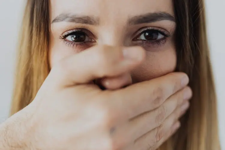 knocked out tooth -- woman covering her mouth with her hand