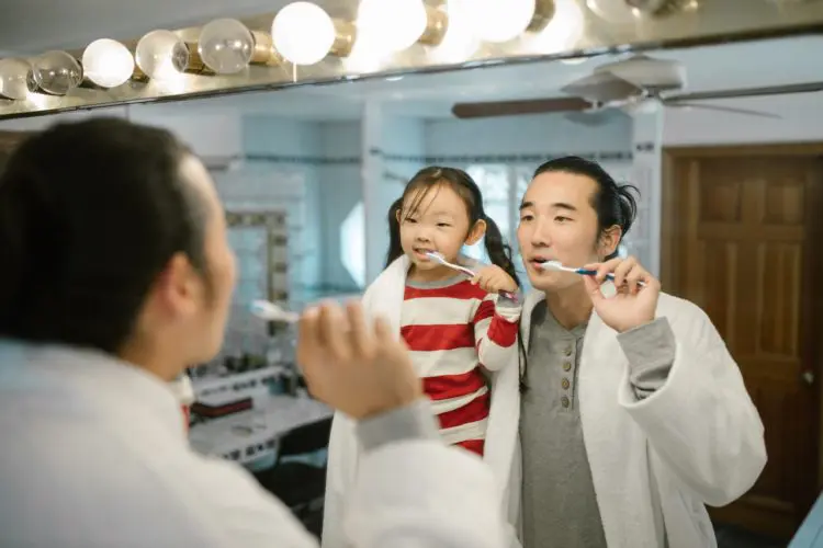 cavities in baby teeth - dad and daughter brushing teeth