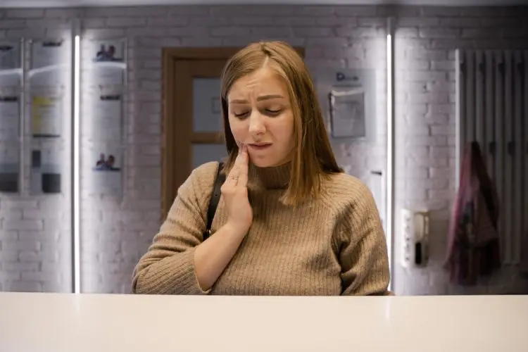 why do cavities hurt - woman holding jaw in pain