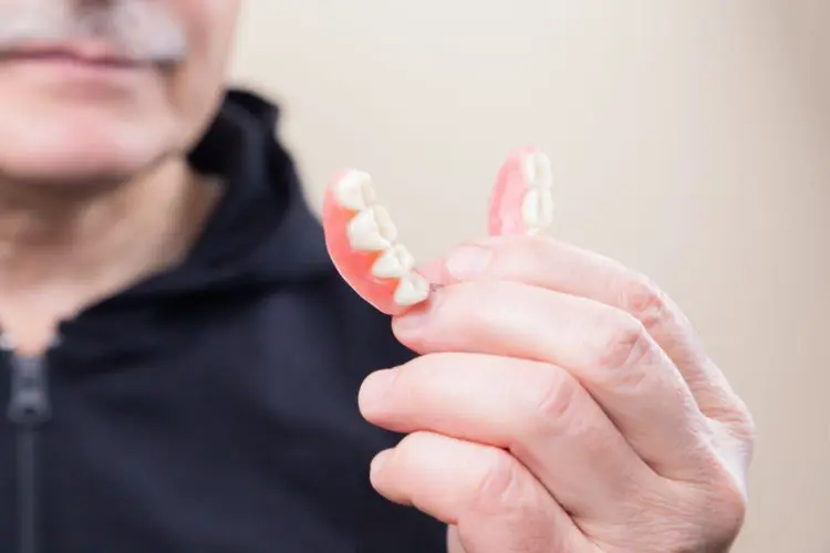 closeup of dentures in older man's hand