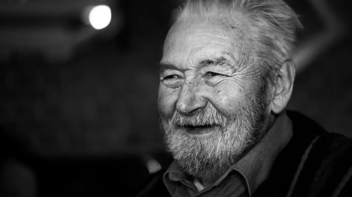 black and white image of man smiling with no teeth