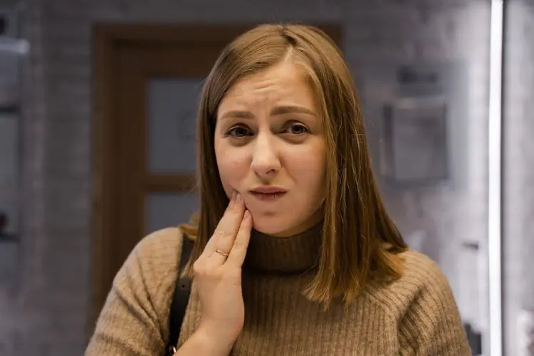 woman with toothache holding hand to cheek