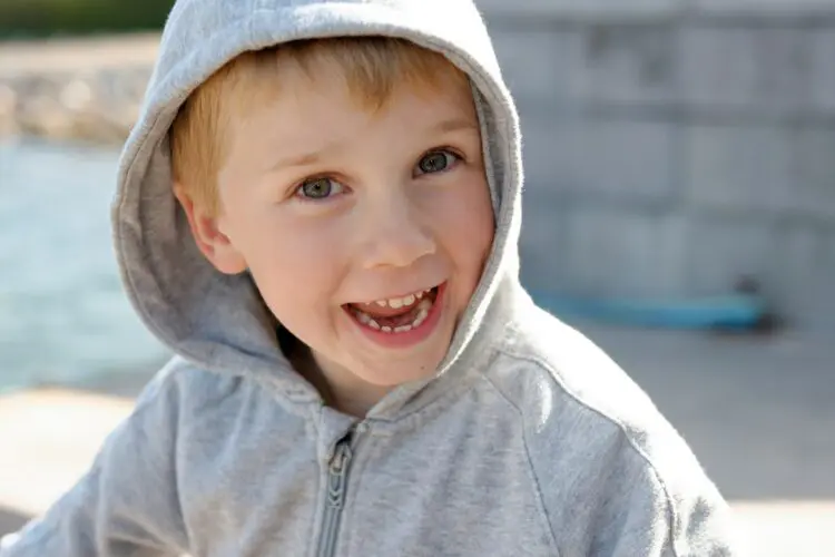 boy in grey hoodie with big smile