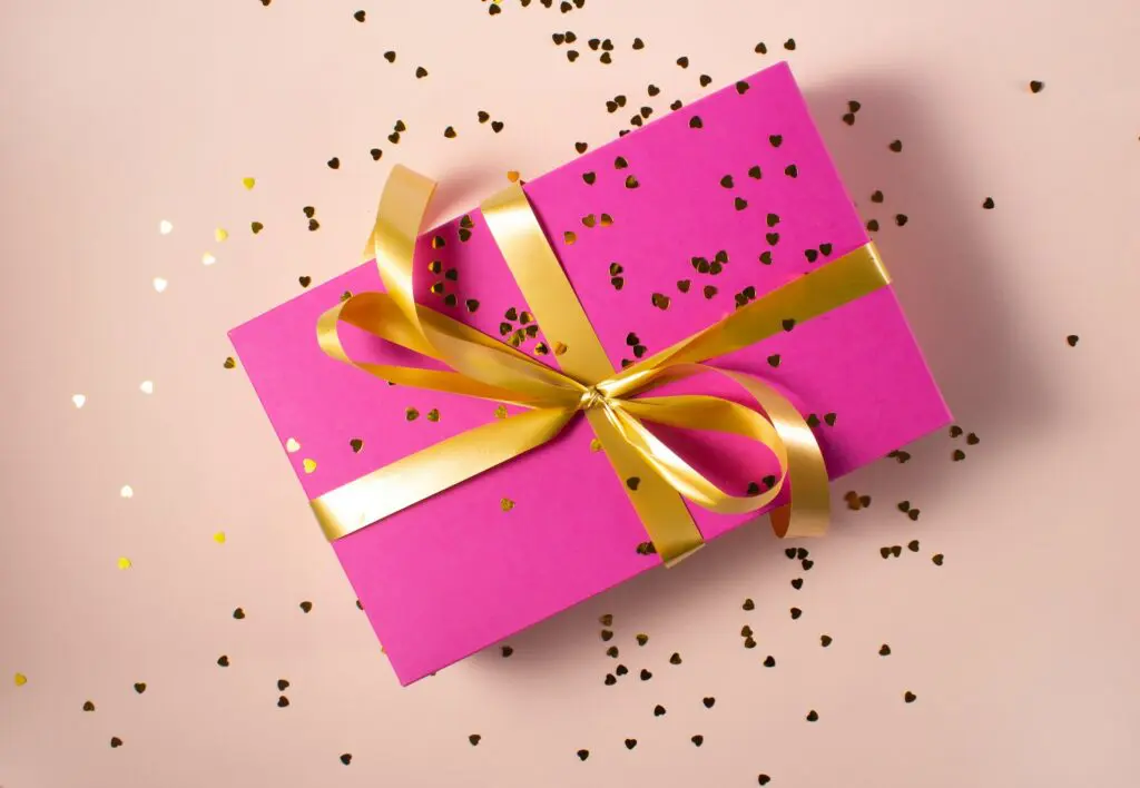 gift wrapped in pink with gold bow and glitter