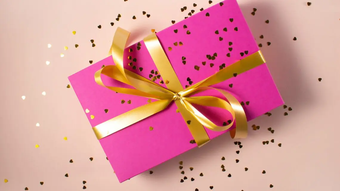 gift wrapped in pink with gold bow and glitter