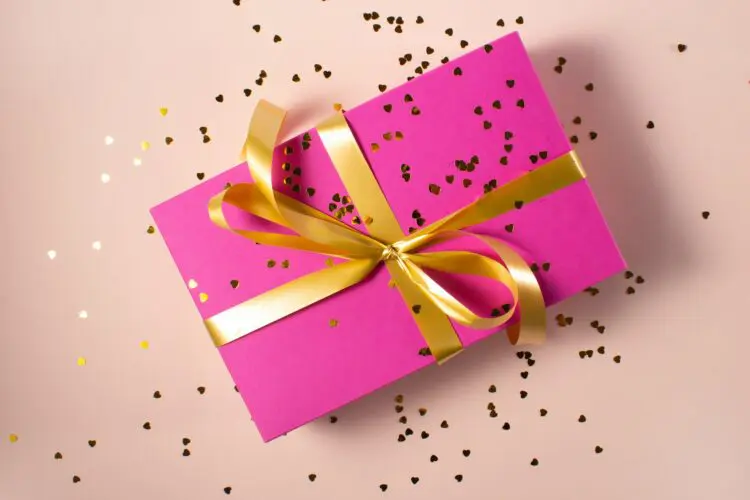 gift wrapped in pink with gold bow and glitter