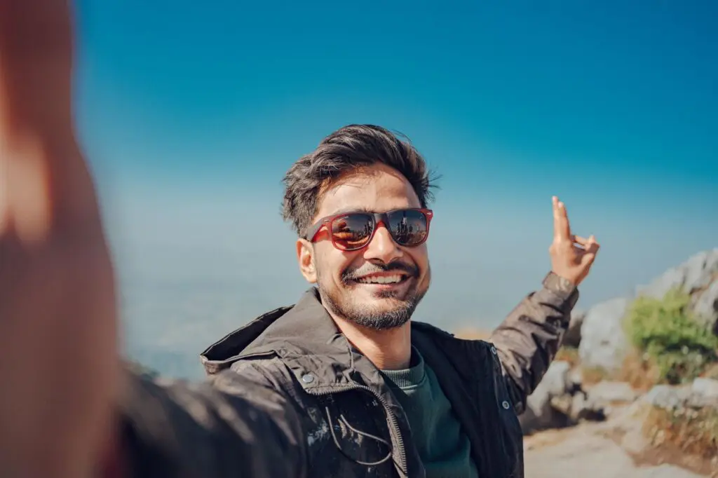 man smiling hiking mountain