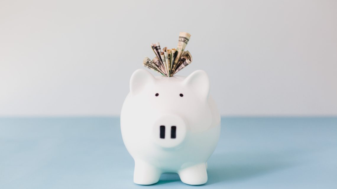 dental savings plan flagstaff - piggy bank with lots of currency bills stuck in it