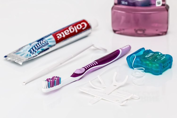 floss daily - toothpaste, toothbrush, floss thread all laid out