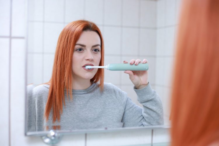 brushing teeth wrong - woman brushing teeth