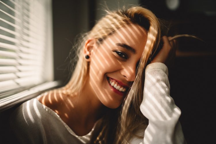 blonde woman smiling - how to keep gums healthy