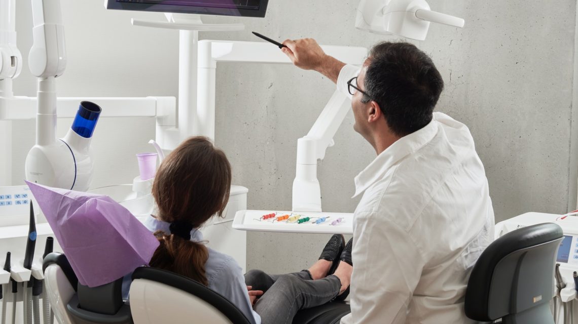 dental deep cleaning -- Dentist reviewing x-ray with patient