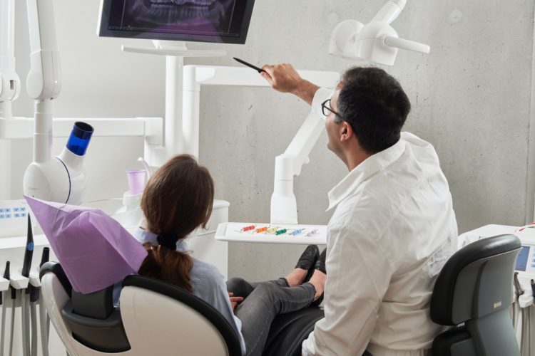 dental deep cleaning -- Dentist reviewing x-ray with patient