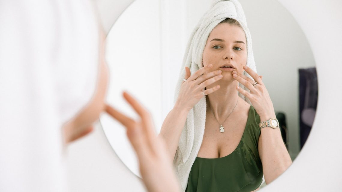 black spot on gums - woman checking mouth in the mirror