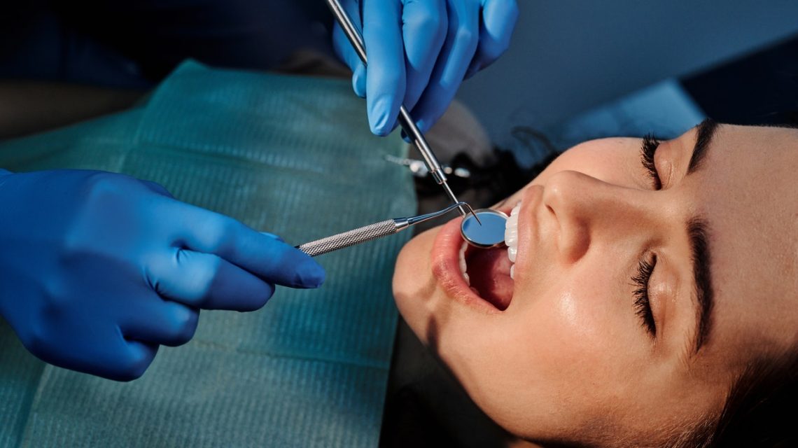 non-surgical root canal -- woman having teeth examined by dentist