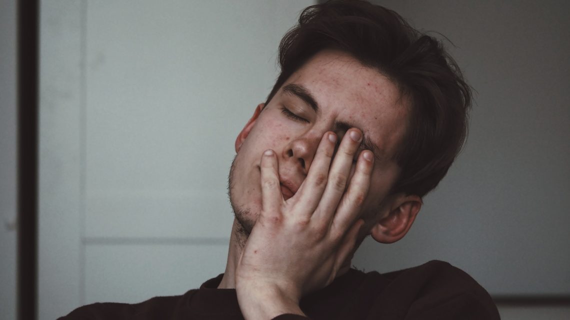 how to stop teeth grinding - man with hand on face