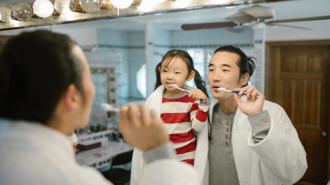 cavities in baby teeth - dad and daughter brushing teeth