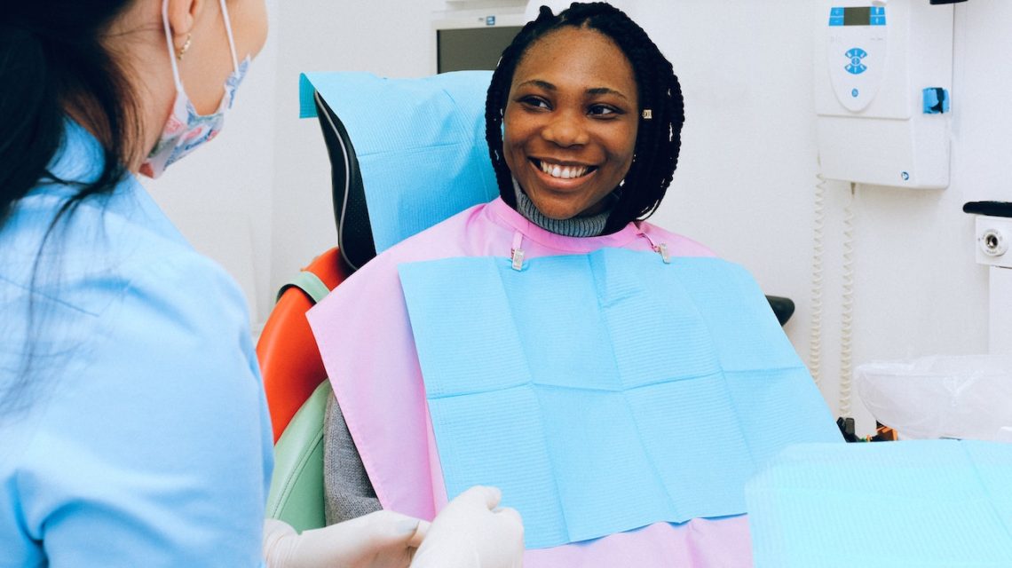 woman in dentists chair smiling at dentist