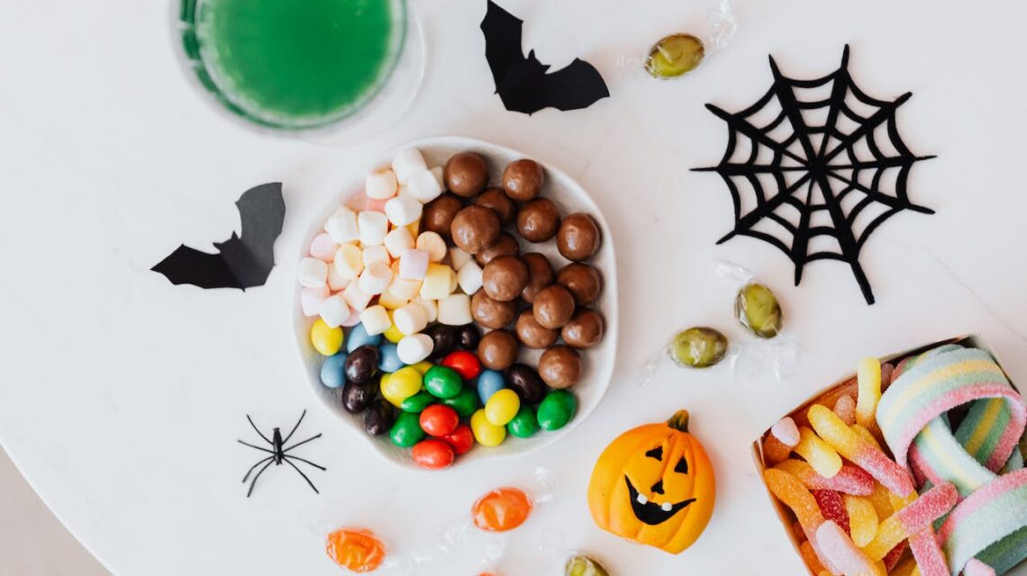 bowl of candy and halloween decorations on table