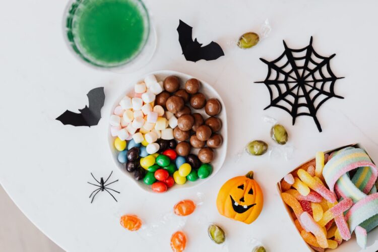 bowl of candy and halloween decorations on table