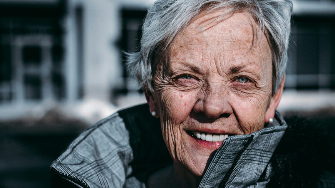 older woman smiling in winter coat