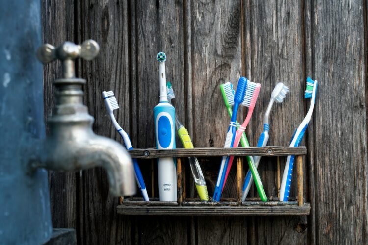 many toothbrushes on a shelf - are electric toothbrushes better